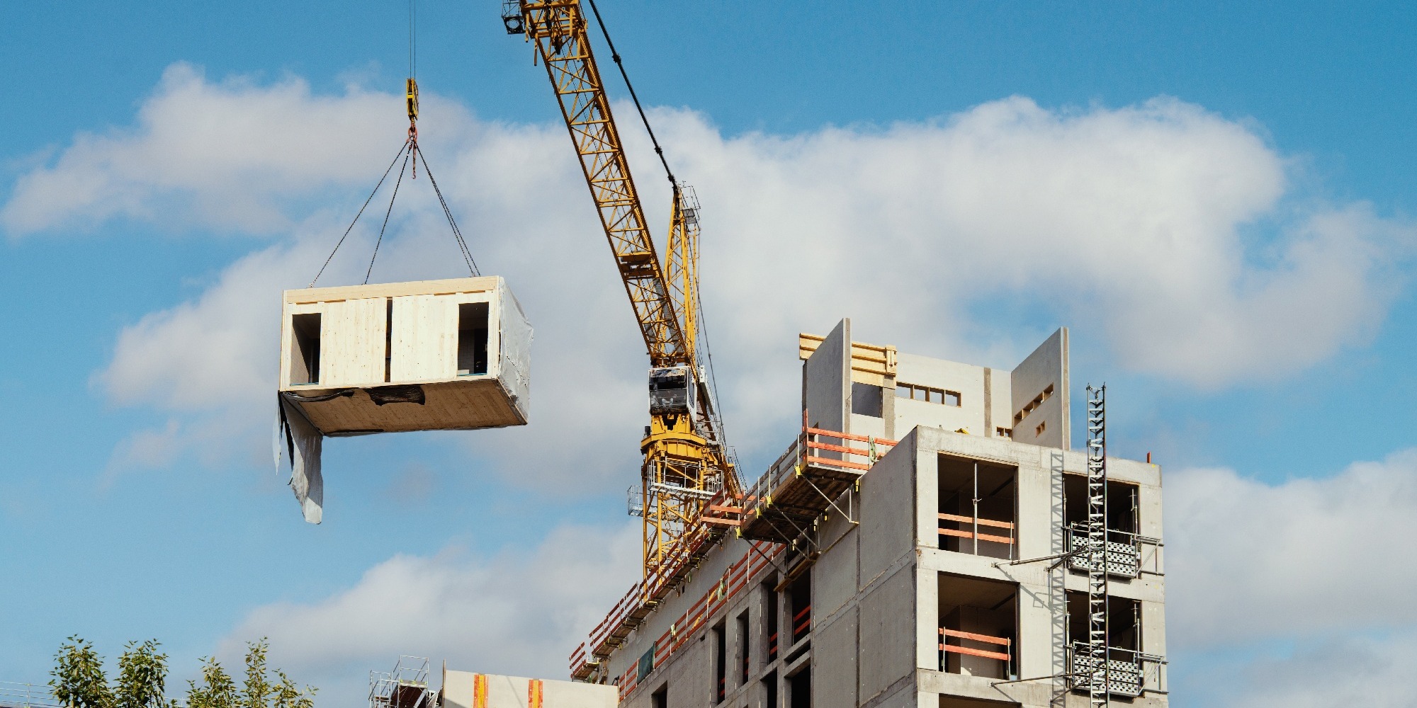 A crane lifting a modular office for sustainable construction